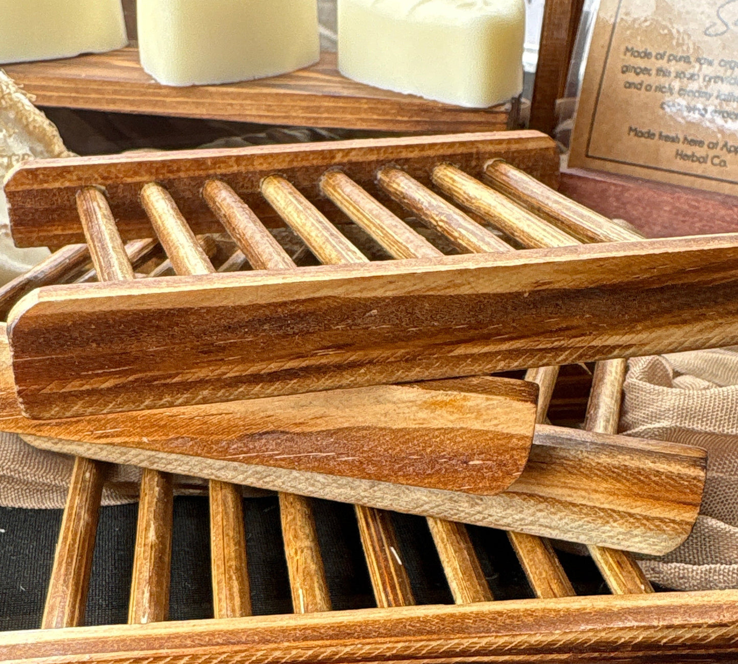 Wooden soap dish with soap bars on a textured surface